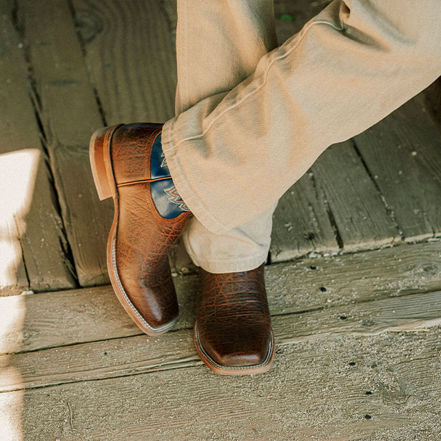 A Man Wearing the Jinglebob 11" Pull-On Western Boots in Brown